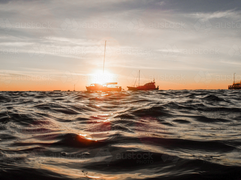 Dawn over ocean with boats in background - Australian Stock Image