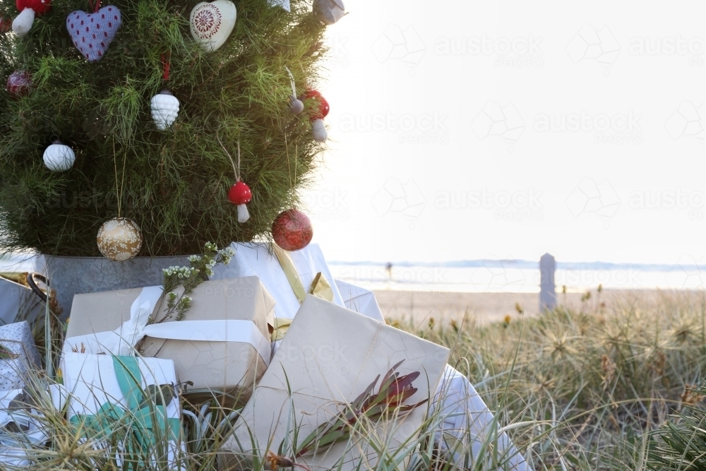 Decorated Christmas tree with presents and beach at sunrise - Australian Stock Image
