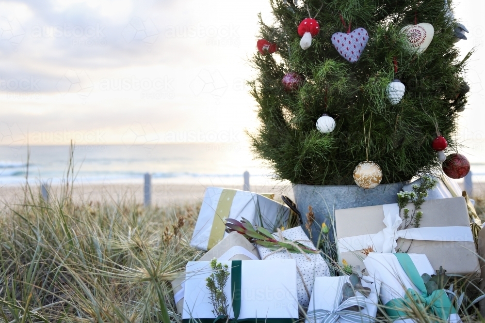 Decorated Christmas tree with presents at beach - Australian Stock Image