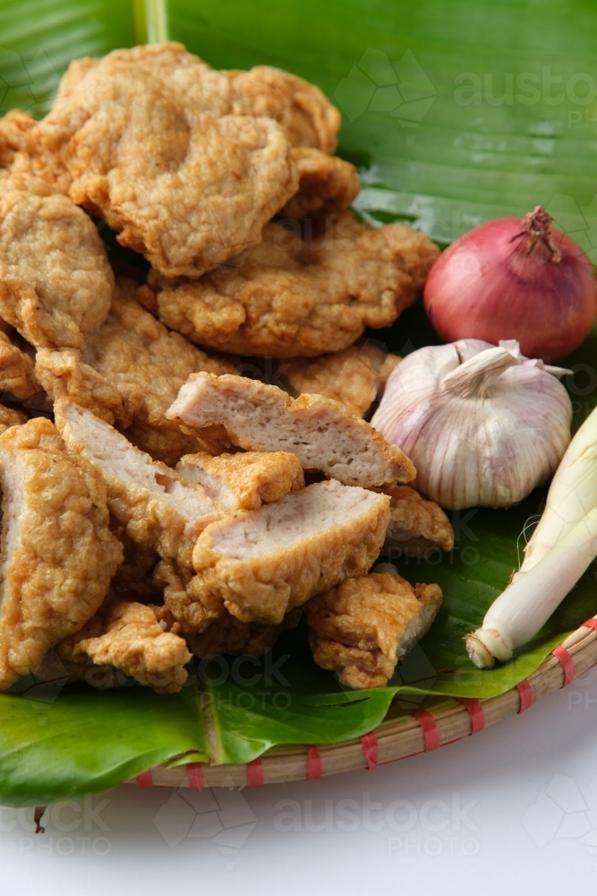 Deep fried Cha Lua slices served on a banana leaf in a woven basket. - Australian Stock Image