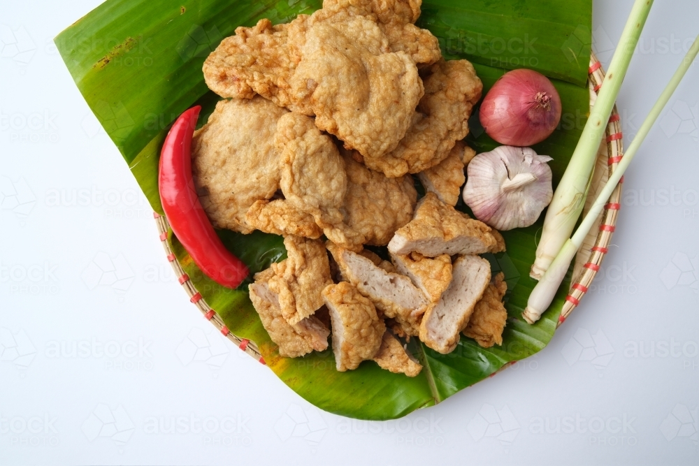 Deep fried Cha Lua slices served on a banana leaf in a woven basket. - Australian Stock Image