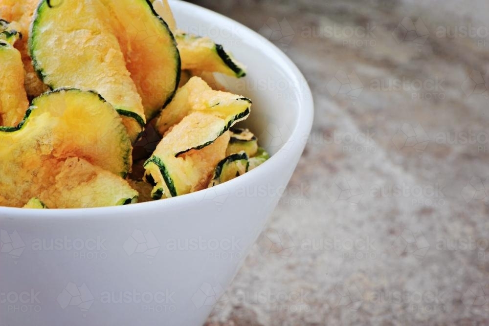deep fried zucchini chips in white bowl - Australian Stock Image