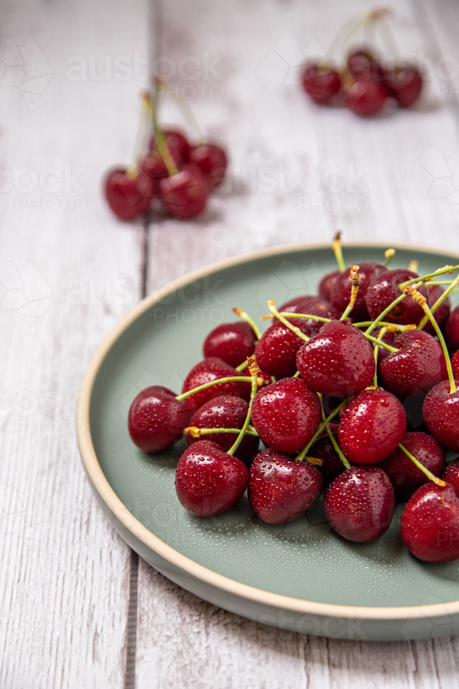wet red cherries on a plate - Australian Stock Image