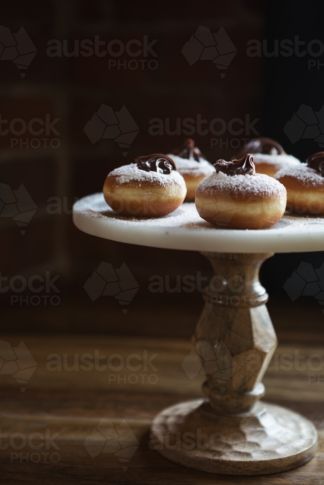 Delicious chocolate topped donuts on a vintage cake stand with space for recipe text - Australian Stock Image