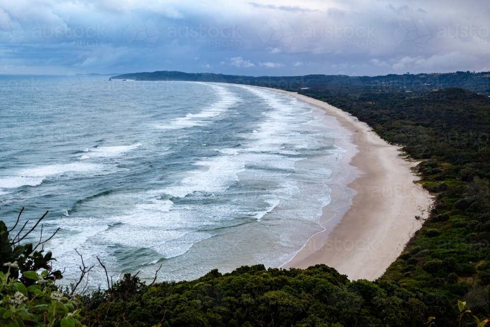 Deserted beach as waves and clouds roll in - Australian Stock Image