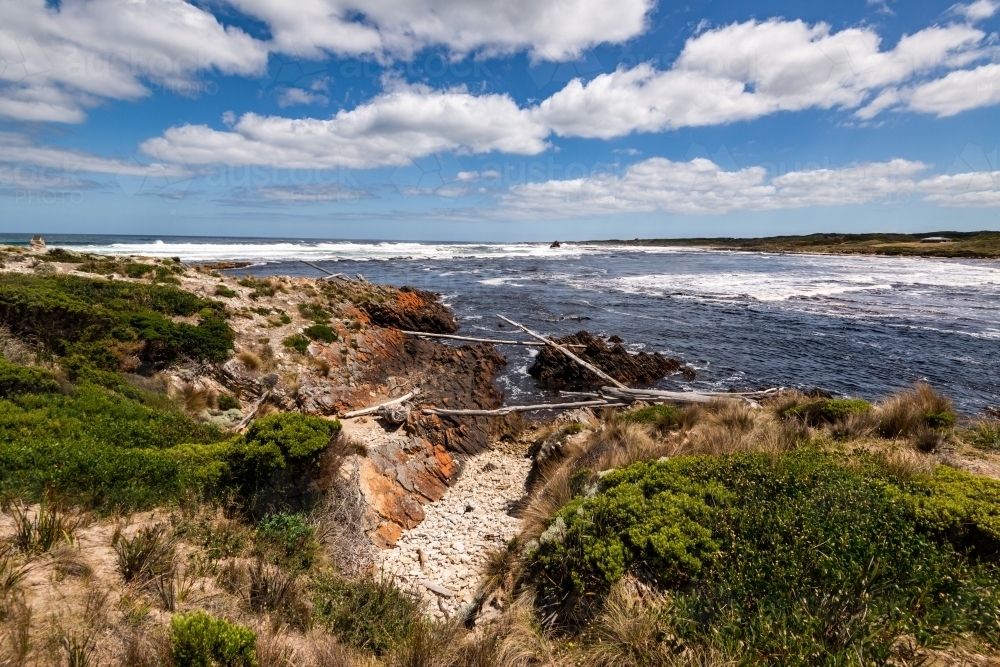 Desolate, rugged coastal scene with dramatic cloudy blue sky - Australian Stock Image