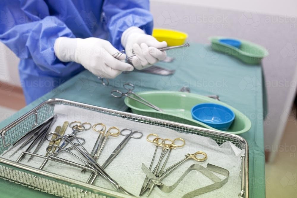 Detail of a theatre nurse preparing equipment for surgery in a hospital operating theatre - Australian Stock Image