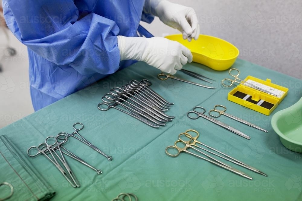 Detail of a theatre nurse preparing equipment for surgery in a hospital operating theatre - Australian Stock Image