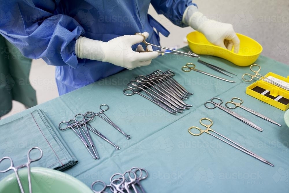 Detail of a theatre nurse preparing equipment for surgery in a hospital operating theatre - Australian Stock Image