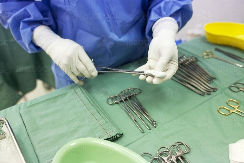 Detail of a theatre nurse preparing equipment for surgery in a hospital operating theatre - Australian Stock Image