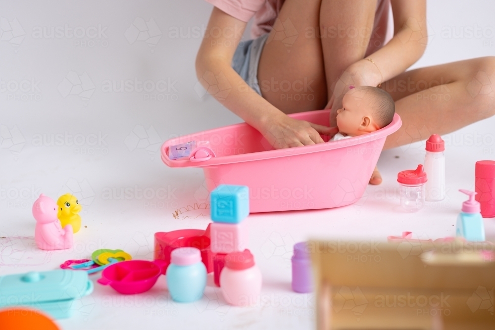 detail of child playing with baby doll toys - Australian Stock Image