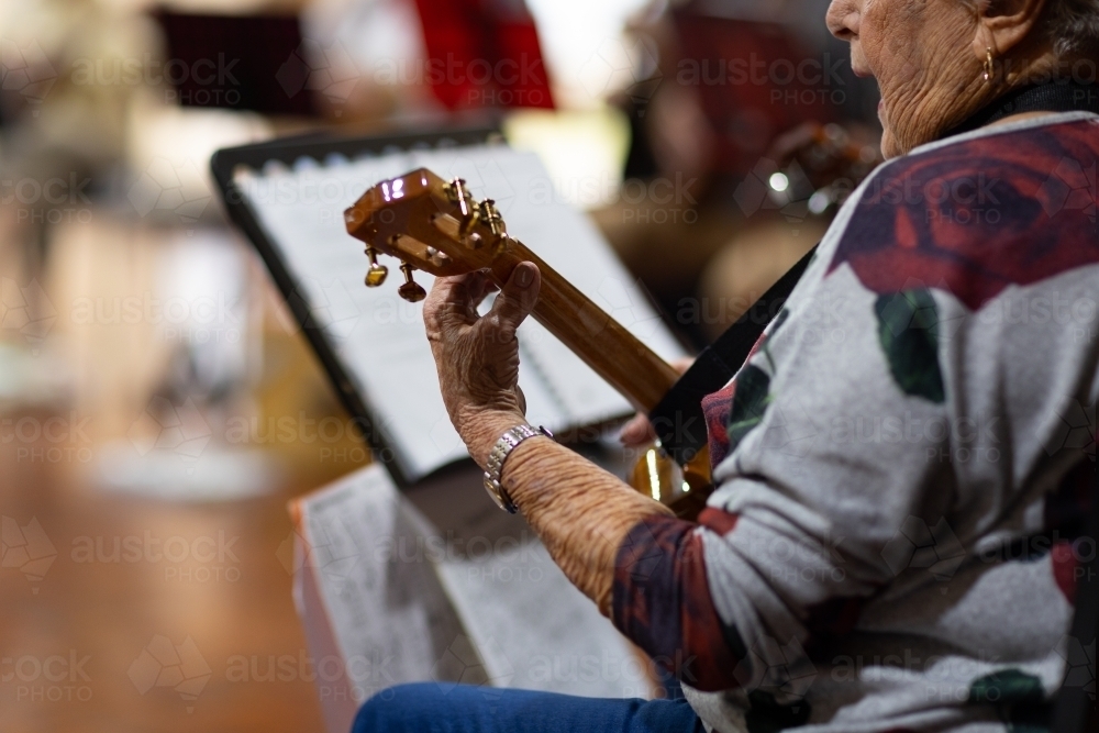 detail of elderly lady playing ukulele - Australian Stock Image