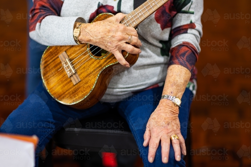 detail of elderly woman holding ukulele - Australian Stock Image