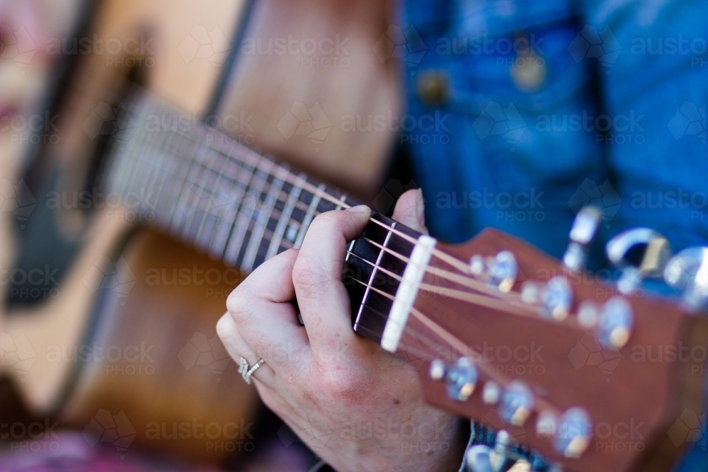 Detail of fingers on guitar strings - Australian Stock Image