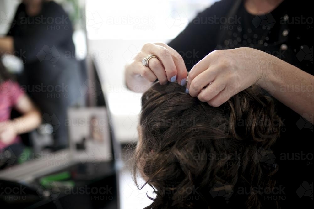 Detail of hairdresser styling a woman's hair - Australian Stock Image