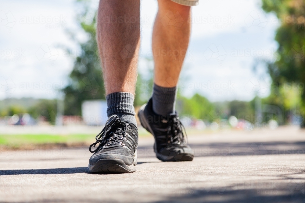 Detail of joggers shoes on footpath - Australian Stock Image