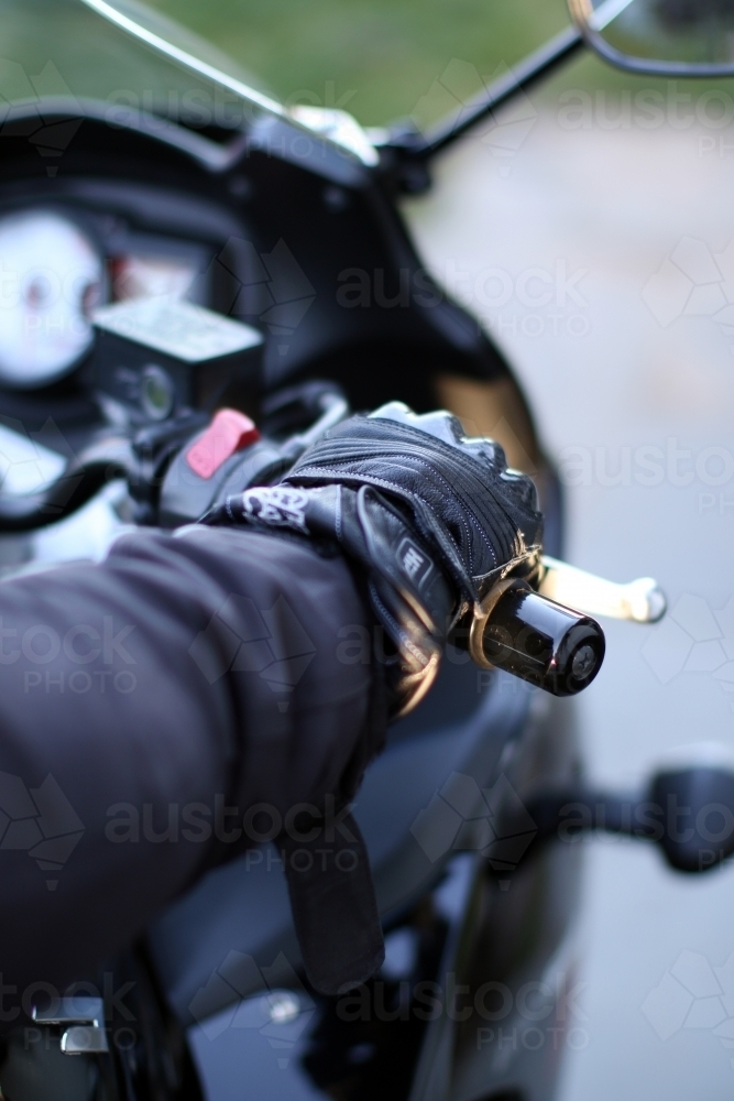 Detail of motorbike glove holding handlebar - Australian Stock Image