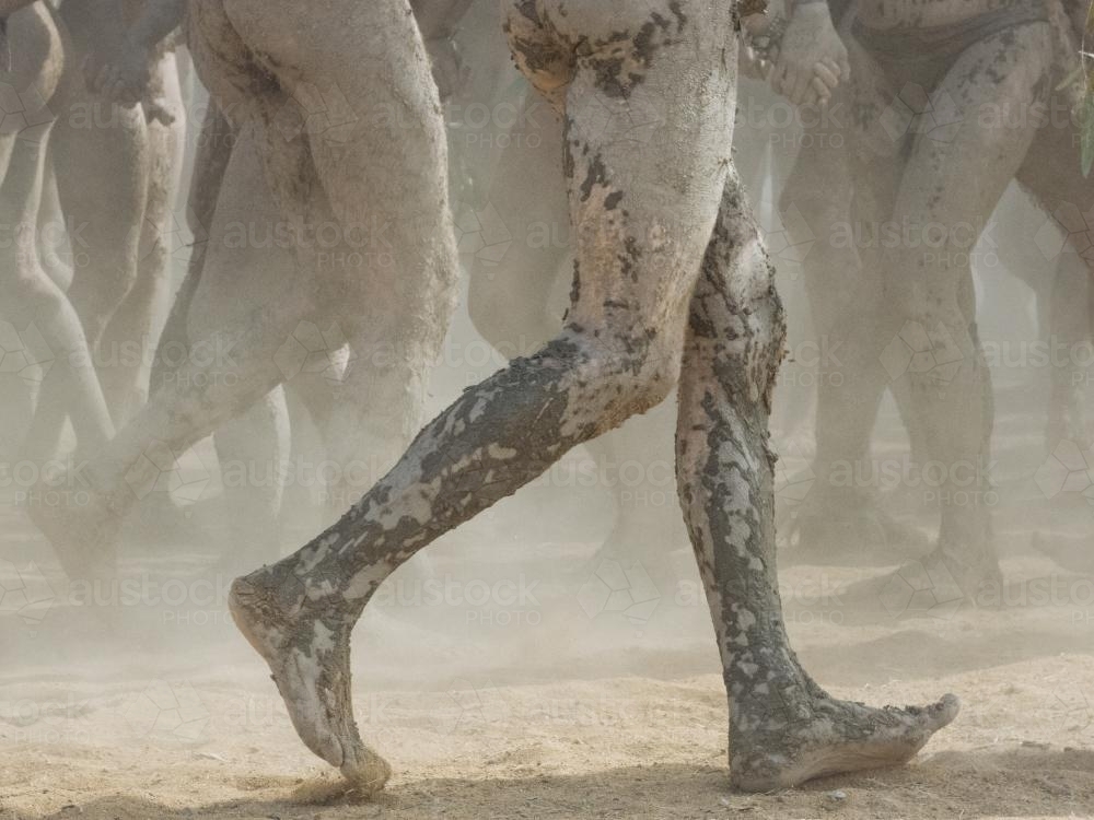 Detail of muddy legs dancing with festival group - Australian Stock Image