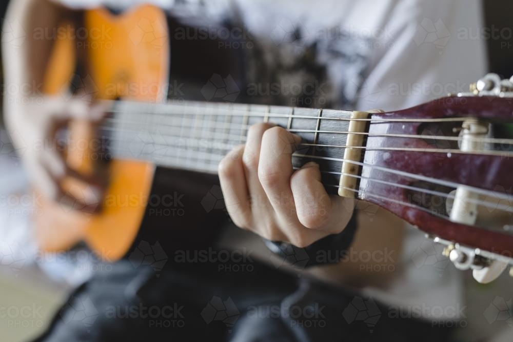 Detail of teenage Boy playing guitar - Australian Stock Image