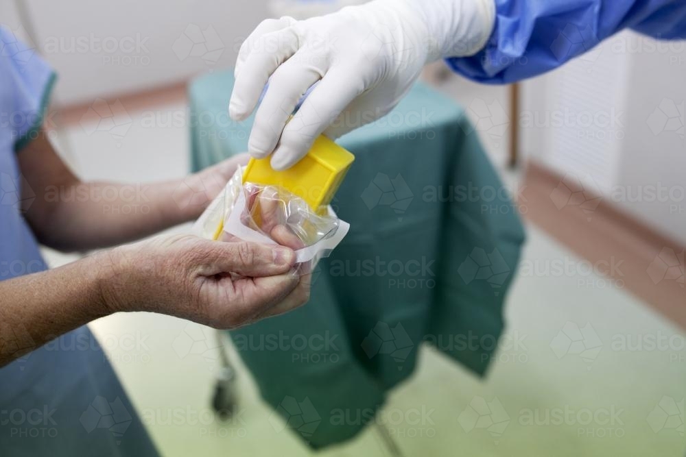 Detail of two nurses preparing equipment for surgery in a hospital operating theatre - Australian Stock Image