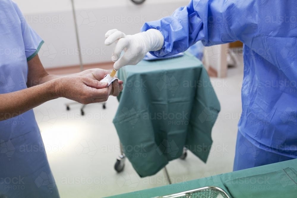 Detail of two nurses preparing equipment for surgery in a hospital operating theatre - Australian Stock Image