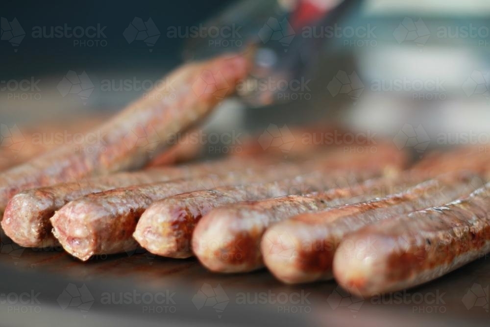 Detail row of BBQ sausages cooking - Australian Stock Image