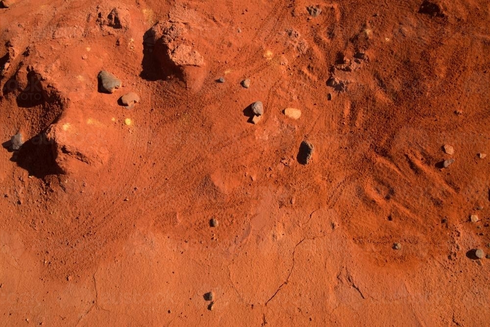 Detail shot of crab prints in bright orange sand with cracks and holes - Australian Stock Image