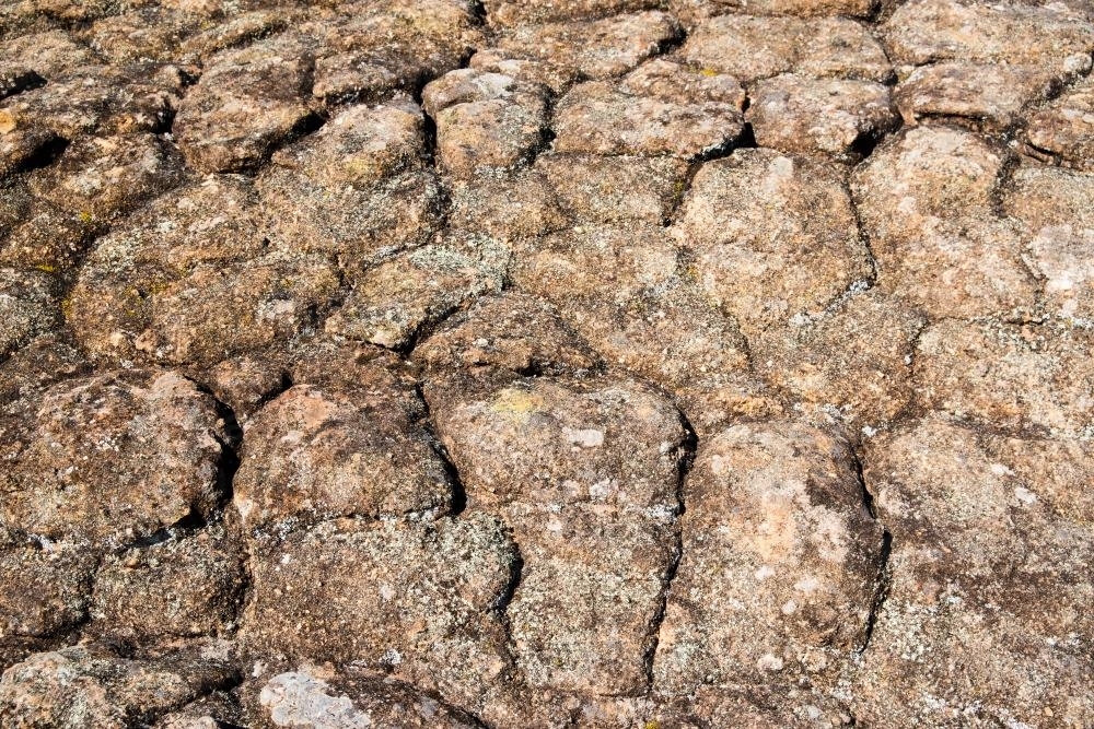 Detail shot of heavily textured and patterned rock with cracks - Australian Stock Image