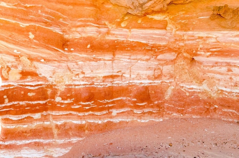 Detail shot of layered and patterned rock with orange, pink and yellow colours - Australian Stock Image