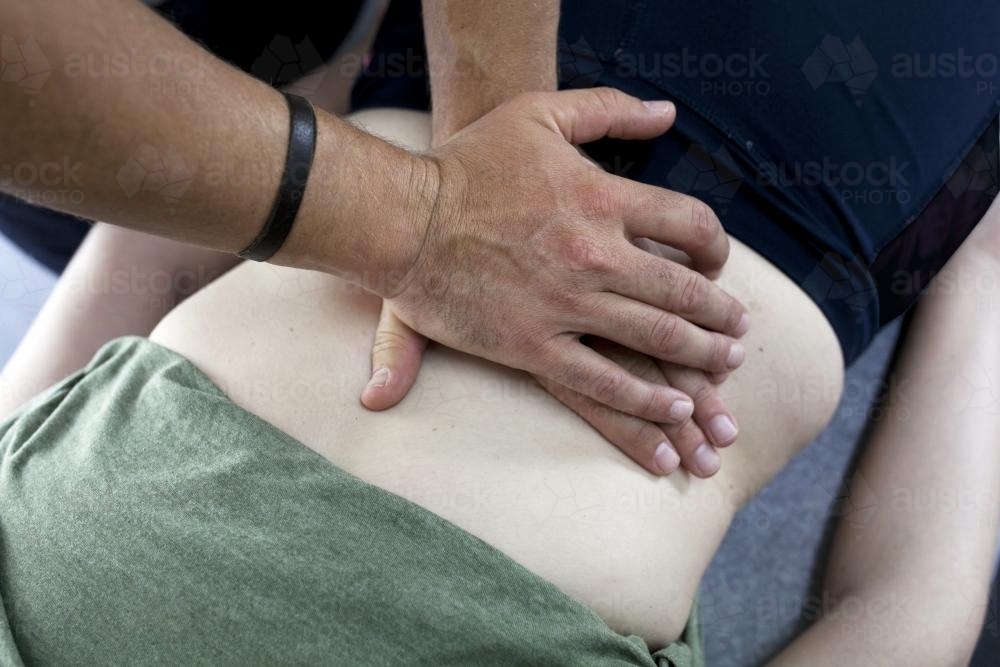 Detail shot of physiotherapist treating a patient's back - Australian Stock Image