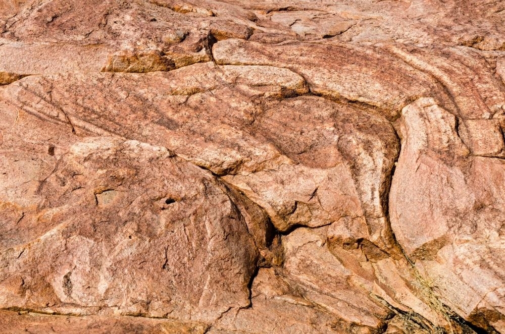 Detail shot of pink and orange rock with texture, patterns and cracks - Australian Stock Image