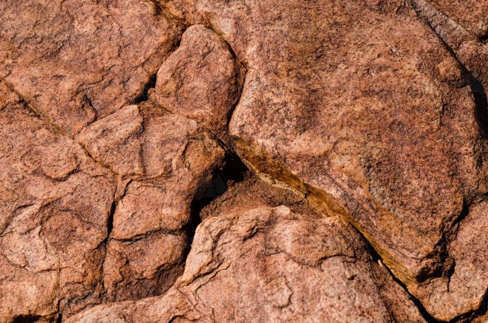 Detail shot of pink and orange rock with texture,  patterns and cracks - Australian Stock Image