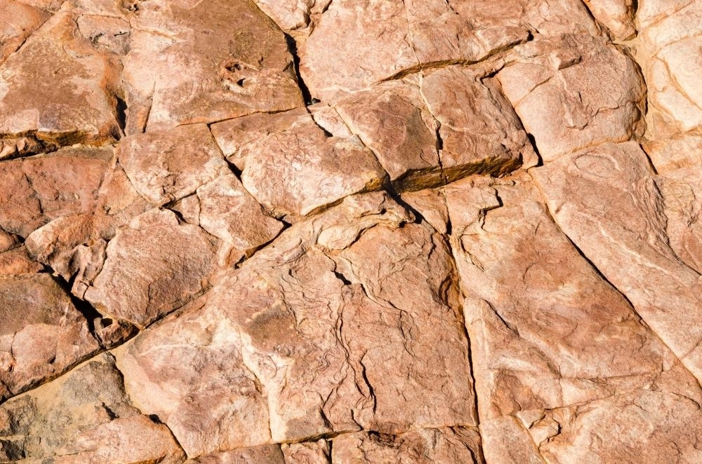 Detail shot of pink, orange rock with patterns and cracks - Australian Stock Image
