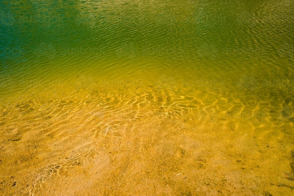 Detail shot of water with ripples and green and yellow tones - Australian Stock Image