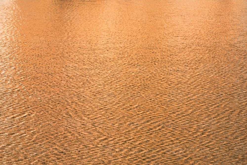 Detail shot of water with ripples and orange tones - Australian Stock Image