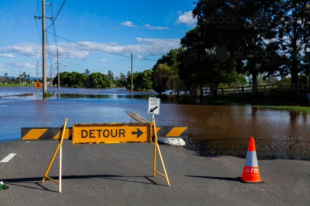 Detour signs blocking a flooded roadway - Australian Stock Image