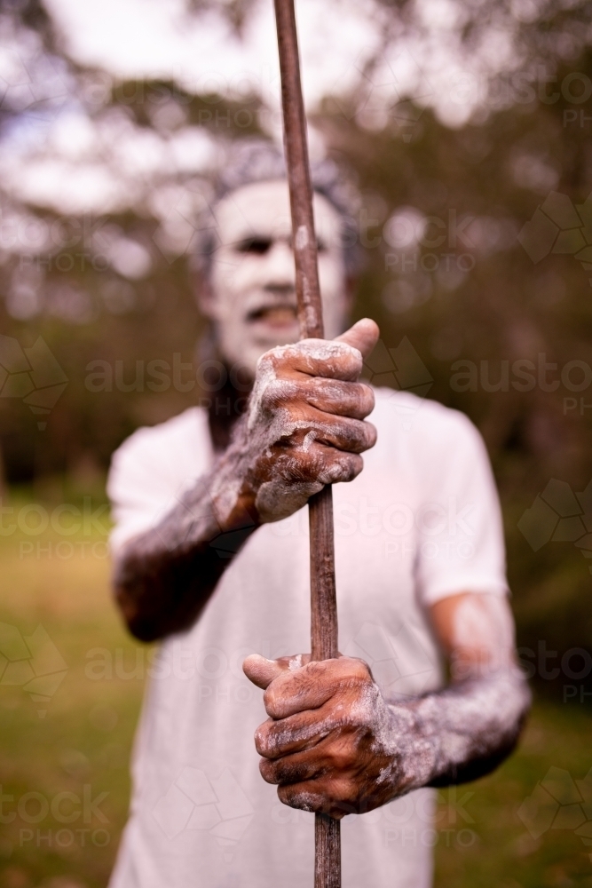 Dharawal man with a painted face holding a spear - Australian Stock Image