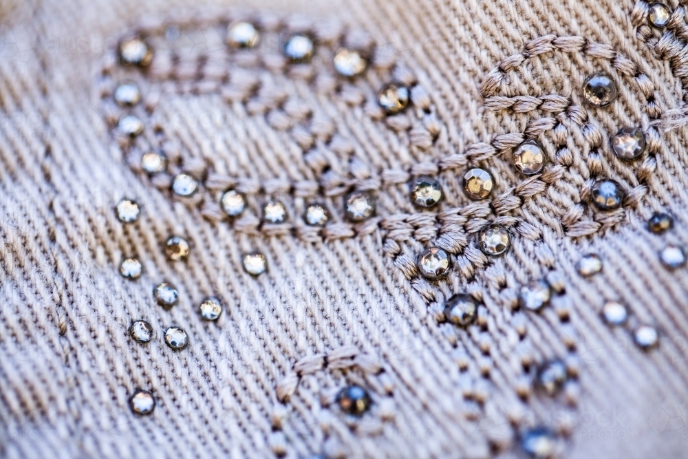 Diamante sparkles and threads making pattern on clothing - Australian Stock Image