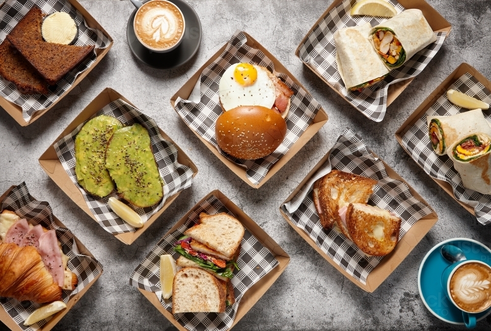 Different types of sandwiches on takeaway containers with a cup of coffee - Australian Stock Image