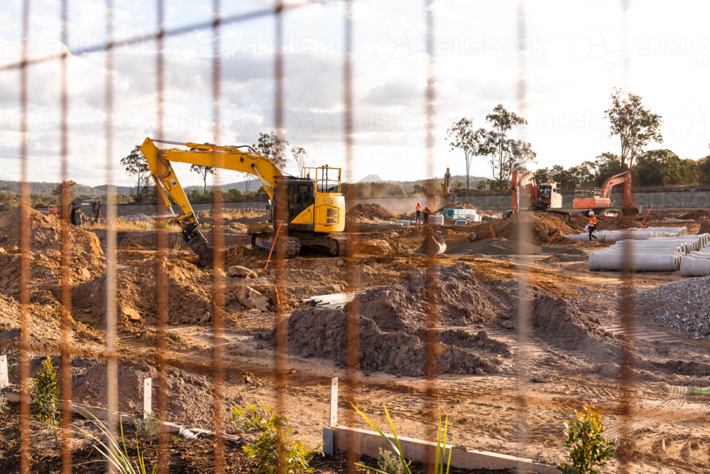 diggers working at a housing estate behind a security fence - Australian Stock Image