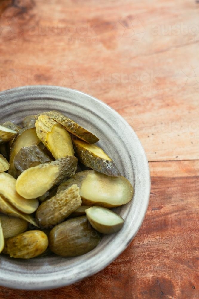 dill pickles in an earthenware bowl - Australian Stock Image