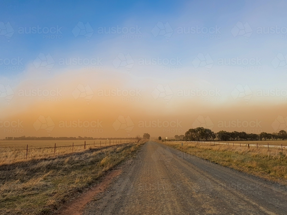 dirt road leading towards approaching dust storm - Australian Stock Image