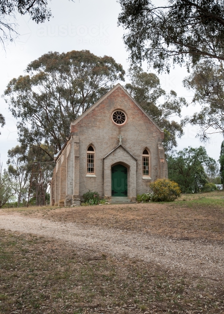 dirt track leading up a hill to a rural church - Australian Stock Image