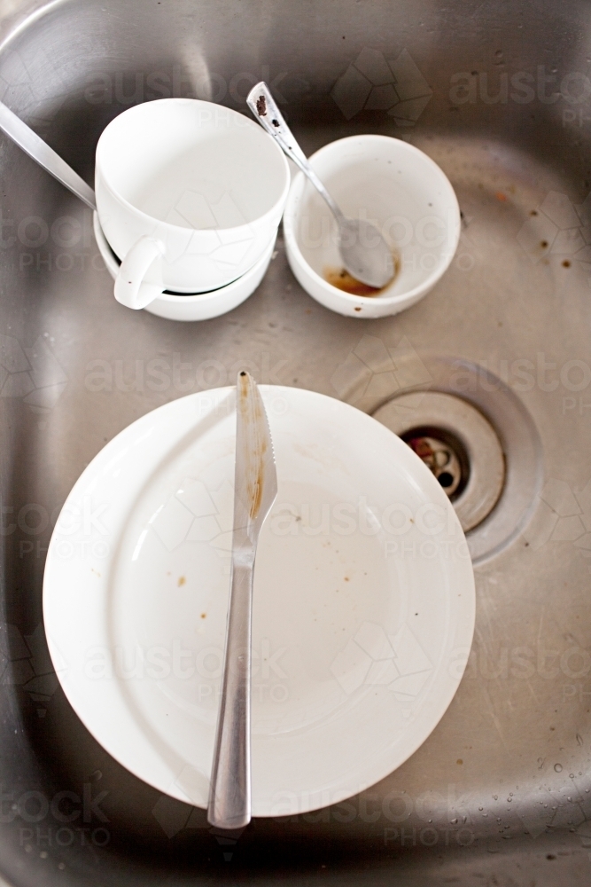 Dirty breakfast dishes sitting in the sink for washing up - Australian Stock Image
