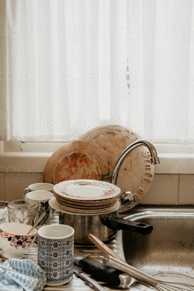Dirty dishes waiting to be washed at the sink. - Australian Stock Image