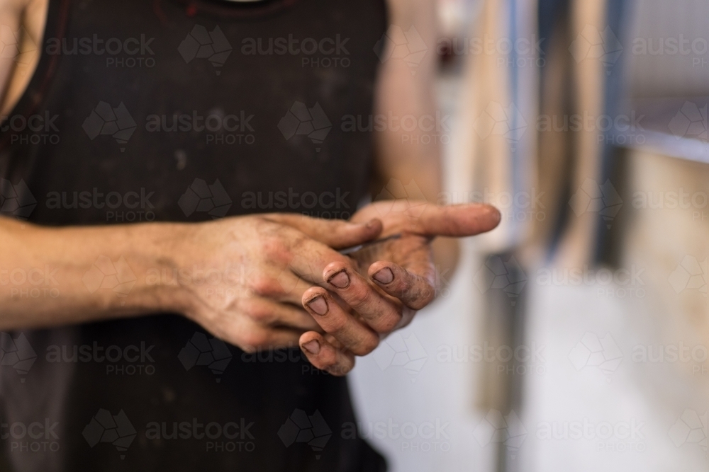 dirty shearers hands holding shearing comb - Australian Stock Image