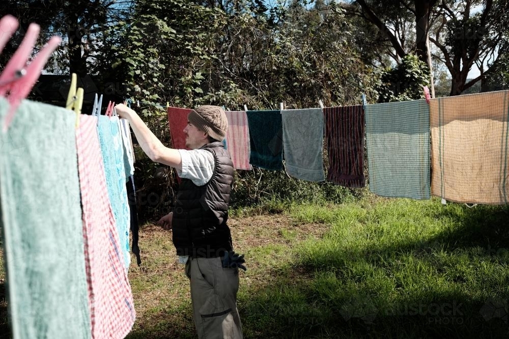 Disabled Man Hanging out Towels to Dry on Clothesline - Australian Stock Image
