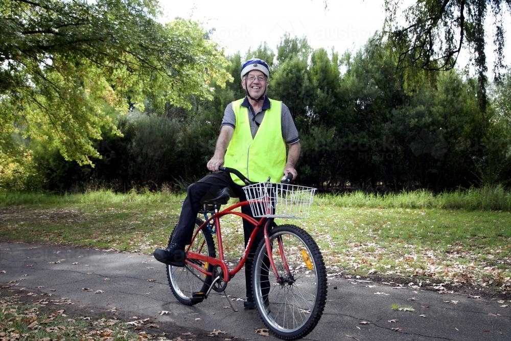 Disabled man in high visibility vest with bike - Australian Stock Image