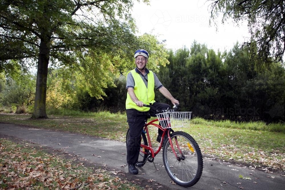 Disabled man in high visibilty vest with bike - Australian Stock Image
