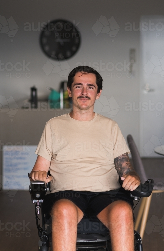 disabled man in wheelchair at home - Australian Stock Image